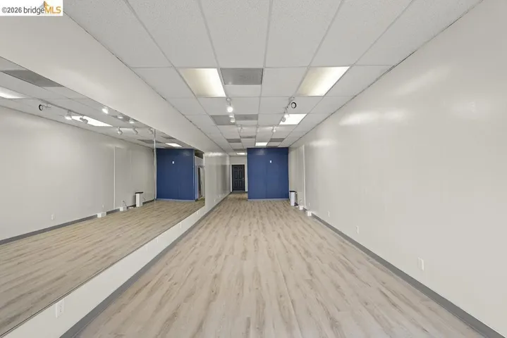 Unfurnished room with a paneled ceiling and light wood finished floors