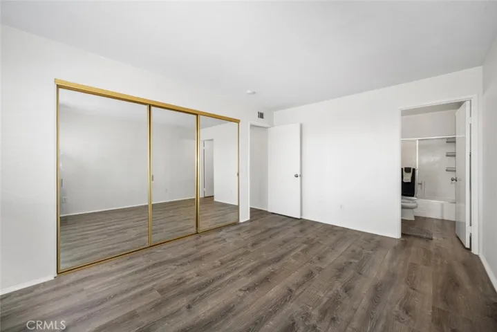 Large closet with three mirrored doors.