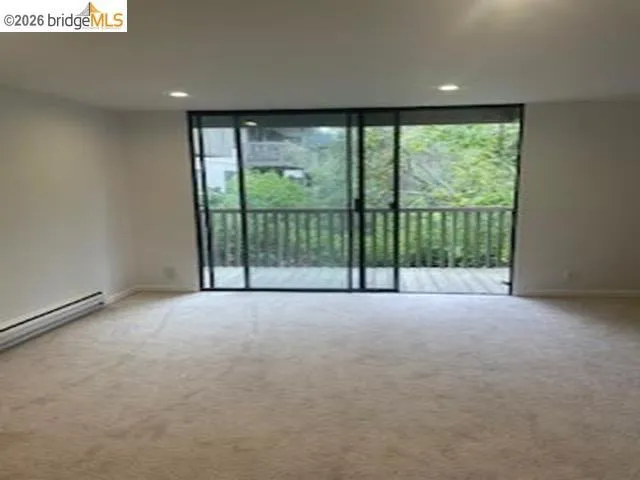 Unfurnished room featuring light carpet, expansive windows, and recessed lighting