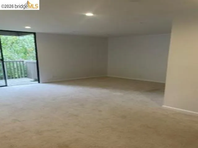 Spare room featuring recessed lighting, light carpet, and expansive windows