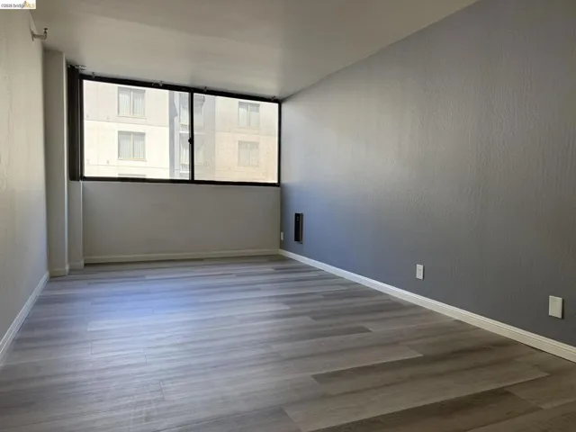 Empty room featuring wood finished floors and a textured wall