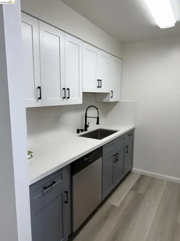 Kitchen with newly installed granite counter top, dishwasher, stainless steel sink and newly white cabinets.