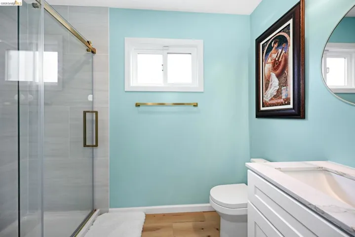 Bathroom with vanity, a shower stall, and light wood-style floors