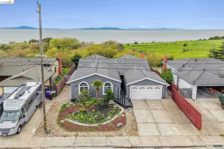 View of front of home featuring a water view, an attached garage, and driveway