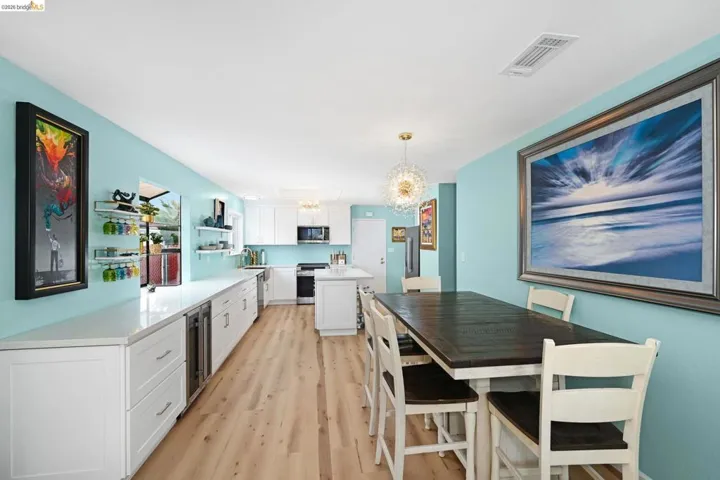 Kitchen featuring white cabinetry, light wood-style floors, a chandelier, stainless steel appliances, and open shelves
