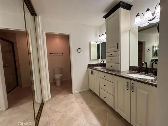 Primary ensuite bathroom with dual sinks and added storage.
