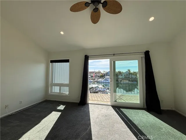 Primary bedroom with vaulted ceilings, ceiling fan.