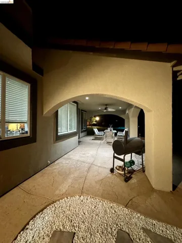 Hall with a textured wall, arched walkways, and a high ceiling