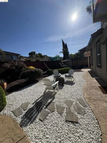 Landscaped backyard featuring white gravel and irregular stepping stones