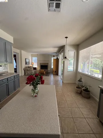 Kitchen island with a light speckled countertop and grey cabinetry