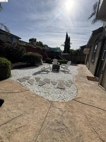 Stamped concrete patio leading to a gravel area with stepping stones
