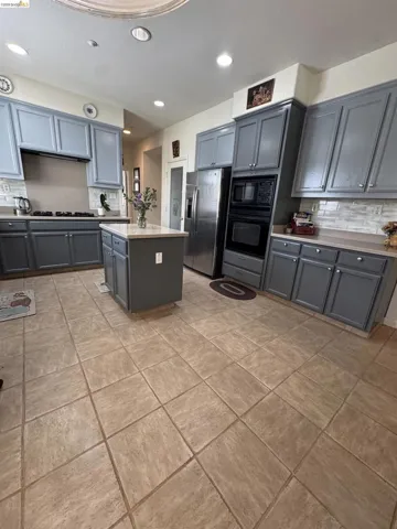 Kitchen featuring gray cabinetry, light-colored countertops, and a subway tile backsplash