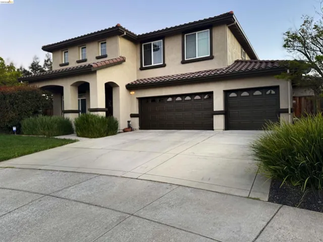 Mediterranean / spanish-style home featuring concrete driveway, stucco siding, an attached garage, a tiled roof, and a garage
