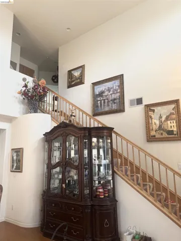 Stairs featuring a high ceiling and wood finished floors