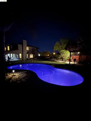 Illuminated freeform swimming pool with integrated cleaning system