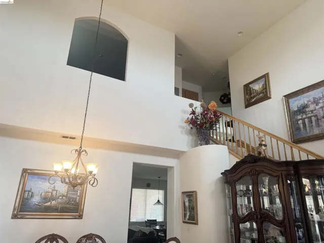 Hallway featuring a chandelier and a high ceiling