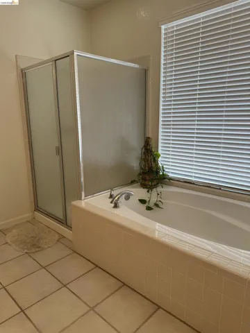 Bathroom featuring a combination shower and tub with a tiled surround
