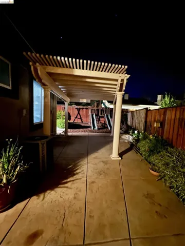 Patio at twilight featuring a playground, a pergola, a patio area, and a fenced backyard