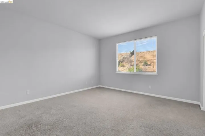 Carpeted spare room featuring baseboards