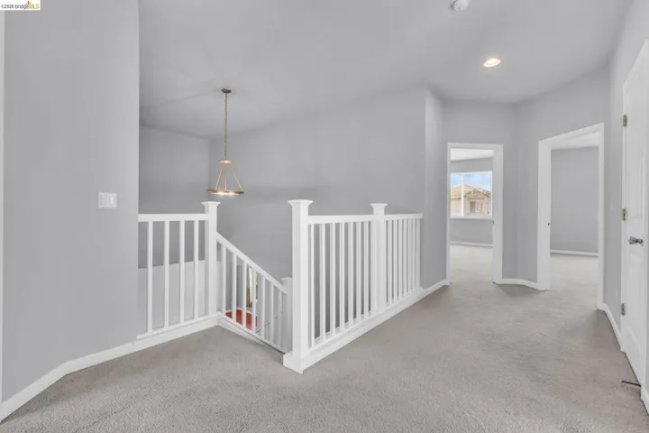 Corridor featuring an upstairs landing, light carpet, and recessed lighting