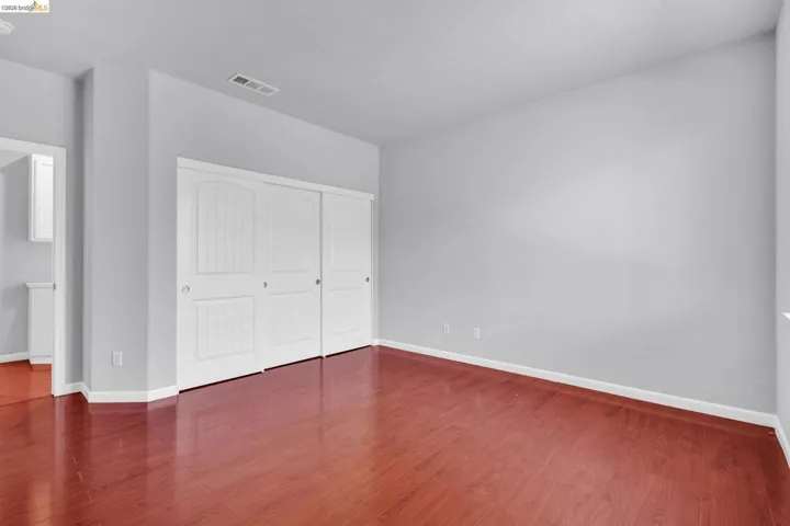Unfurnished bedroom with dark wood-style flooring and a closet