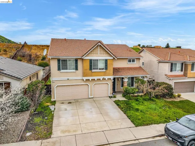 View of front of property featuring stucco siding, a garage, driveway, and a tile roof