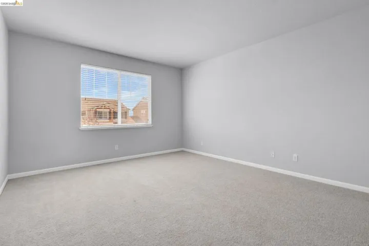 Spare room featuring light colored carpet and baseboards