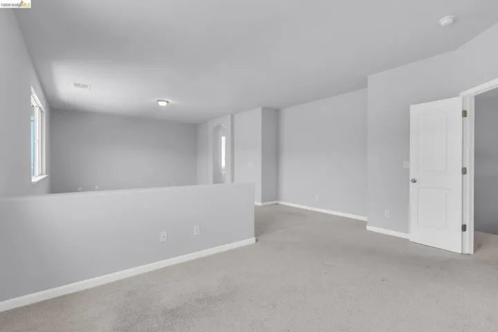 Empty room with light carpet and baseboards