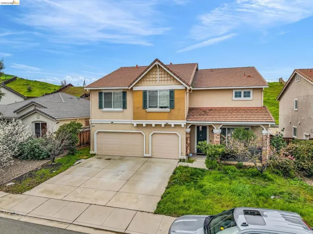 View of front of home featuring stucco siding, a garage, driveway, and a tile roof