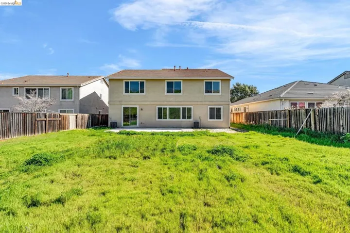 Rear view of property with a patio, stucco siding, and a fenced backyard