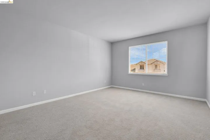 Empty room with carpet floors and baseboards