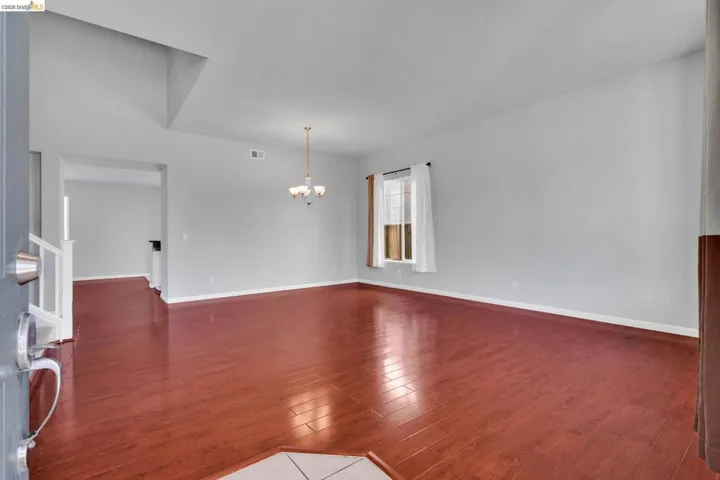 Unfurnished room featuring light wood finished floors and suspended lighting