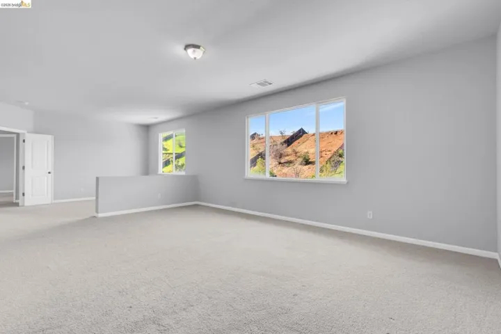 Spare room with baseboards and light carpet