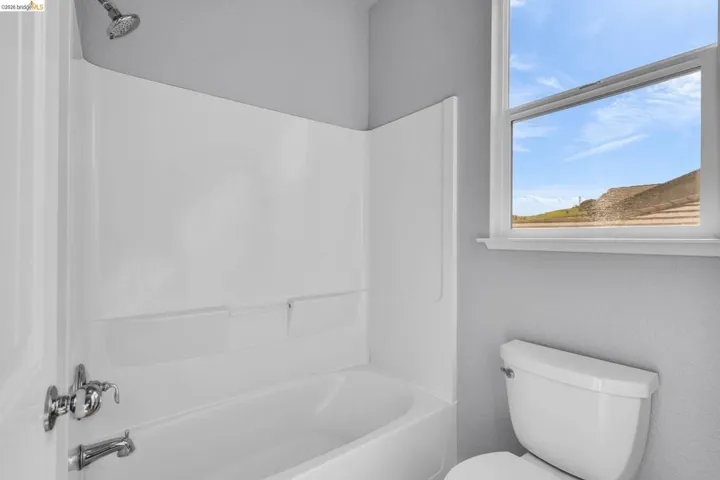 Full bathroom with tub / shower combination and a textured wall