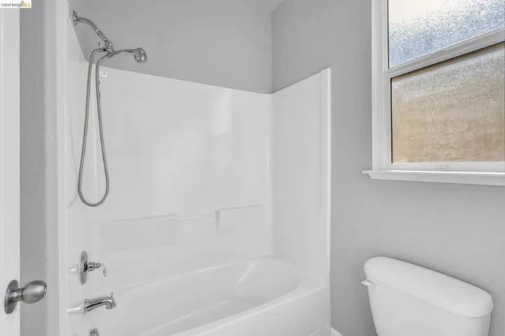 Full bathroom featuring shower / bath combination and a textured wall
