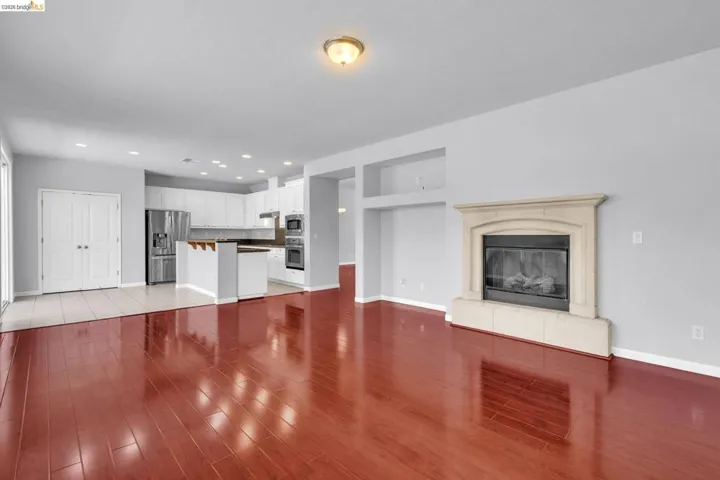 Unfurnished living room with recessed lighting, light wood-style floors, and a glass covered fireplace