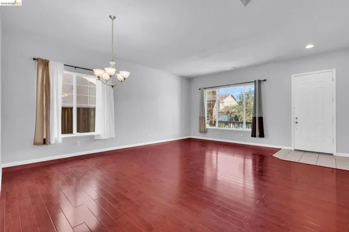 Empty room featuring a chandelier and dark wood-type flooring