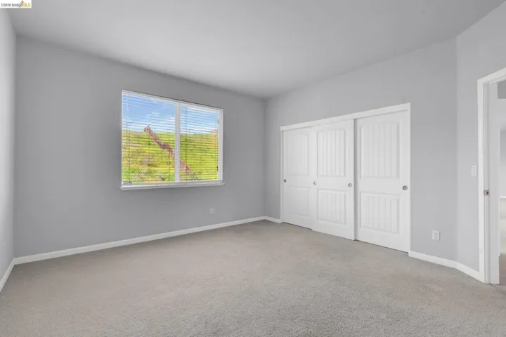 Unfurnished bedroom with light colored carpet and a closet