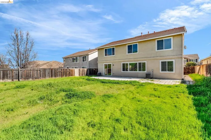 Rear view of house featuring a patio area, a fenced backyard, and stucco siding