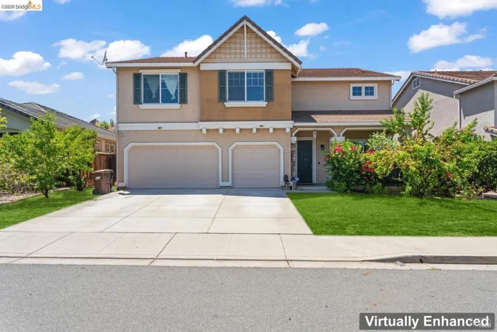 View of front of house with stucco siding, an attached garage, driveway, and a front lawn