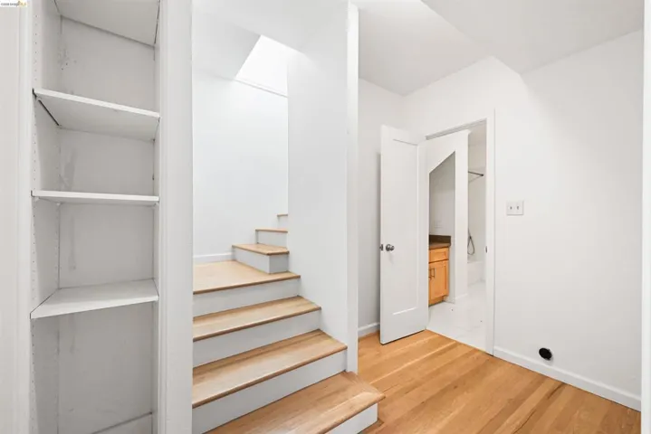 Stairs with wood finished floors and baseboards