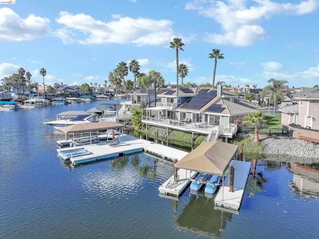 Dock featuring a water view, boat lift, and a residential view