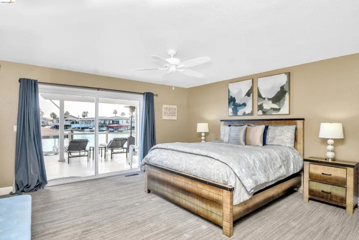 Carpeted bedroom featuring access to outside and a ceiling fan