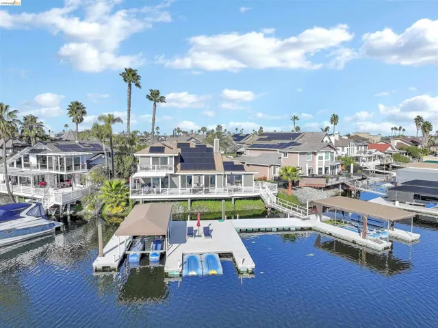 Dock area featuring a water view, a residential view, and boat lift
