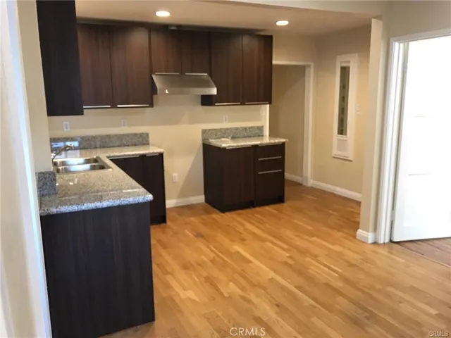 View of Kitchen from Backdoor entry + Entrance to Bedroom with 3/4 bathroom. 2025 Gas stove range and Refrigerator to be included