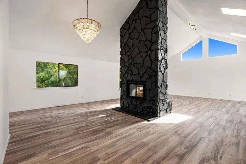 Open Concept, Living and Dining Rooms w/ Dual Sided Fireplace & Vaulted Ceilings.
