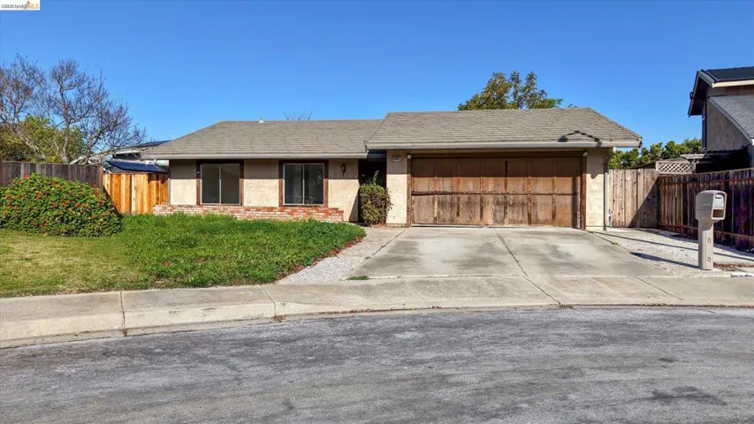 Ranch-style house with stucco siding, driveway, and an attached garage