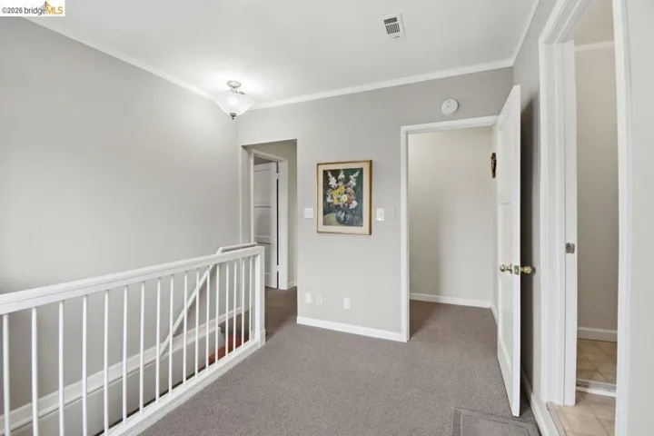 hall with carpet floors and ornamental molding