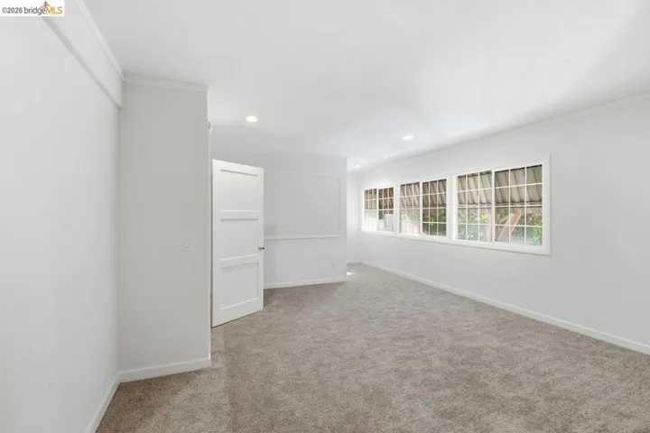 spare room with light colored carpet, crown molding, and recessed lighting