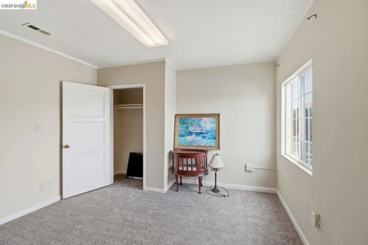 bedroom featuring a closet, light colored carpet, and crown molding